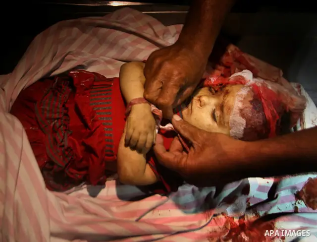 A Palestinian man looks at the body of two-year-old girl, Hadeel al-Hadad, at a hospital in Gaza City June 19, 2012. Israel killed two Palestinians in air strikes and Hamas fired its first cross-border rocket barrages in...