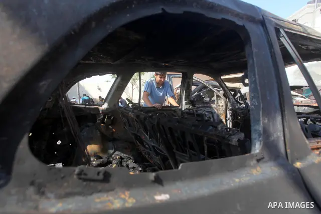 Palestinians are seen through a burnt cars of the potato outside a house after an Israeli air strike in Dir al-Balah in the central in the Gaza Strip June 20, 2012. The Israeli military said it had struck militant sites...