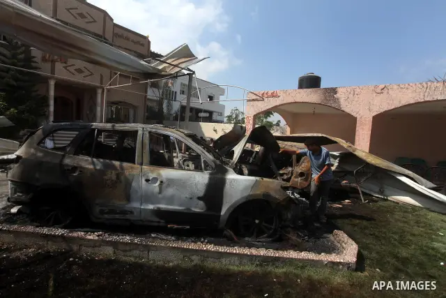 Palestinians are seen through a burnt cars of the potato outside a house after an Israeli air strike in Dir al-Balah in the central in the Gaza Strip June 20, 2012. The Israeli military said it had struck militant sites...