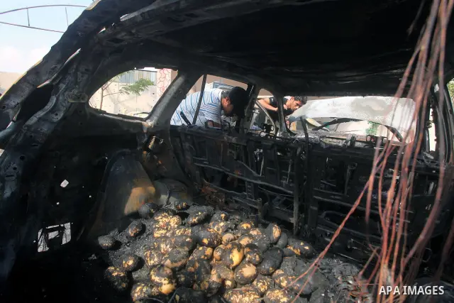 Palestinians are seen through a burnt cars of the potato outside a house after an Israeli air strike in Dir al-Balah in the central in the Gaza Strip June 20, 2012. The Israeli military said it had struck militant sites...