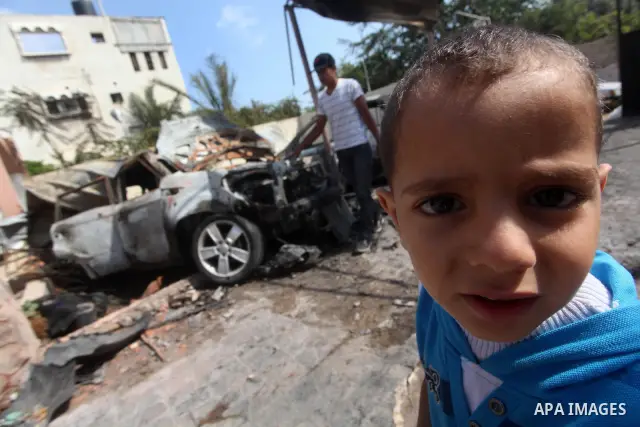 Palestinians are seen through a burnt cars of the potato outside a house after an Israeli air strike in Dir al-Balah in the central in the Gaza Strip June 20, 2012. The Israeli military said it had struck militant sites...