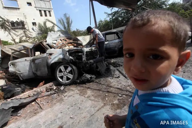 Palestinians are seen through a burnt cars of the potato outside a house after an Israeli air strike in Dir al-Balah in the central in the Gaza Strip June 20, 2012. The Israeli military said it had struck militant sites...