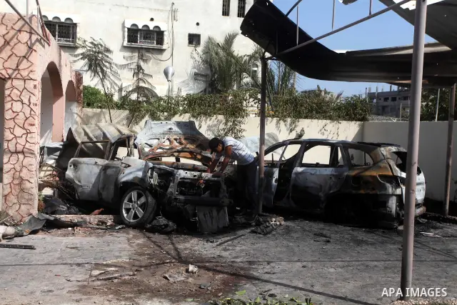 Palestinians are seen through a burnt cars of the potato outside a house after an Israeli air strike in Dir al-Balah in the central in the Gaza Strip June 20, 2012. The Israeli military said it had struck militant sites...