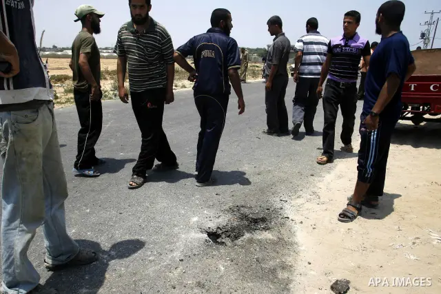 Palestinians look at the blood stained motorcycle riden by 21-year-old Ghaleb Ermilat, when he was killed in an Israeli military strike in Rafah, in the Gaza Strip on June 20, 2012. According to the Isreali military, the...