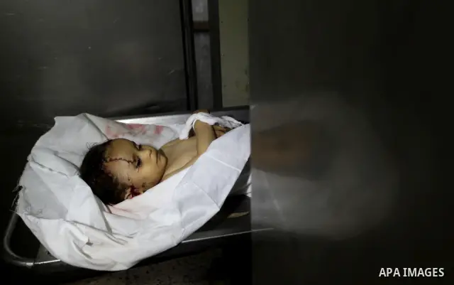 A Palestinian looks at the body of two-year-old girl, Hadeel al-Hadad, at the morgue in the al-Shifa hospital in Gaza City on June 20, 2012. There was no let-up in rocket fire from Gaza with at least 10 hitting the Jewis...