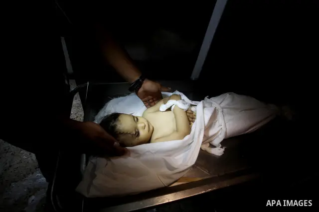A Palestinian looks at the body of two-year-old girl, Hadeel al-Hadad, at the morgue in the al-Shifa hospital in Gaza City on June 20, 2012. There was no let-up in rocket fire from Gaza with at least 10 hitting the Jewis...