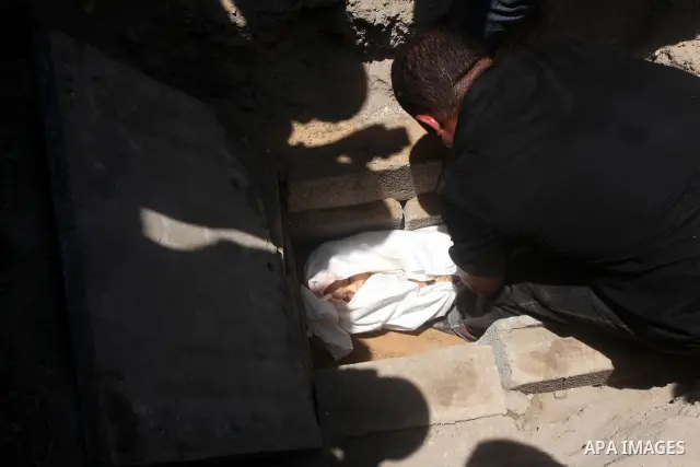 A Palestinian relative buries the body of two-year-old Hadeel al Hadad, after her funeral in Gaza City, Wednesday, June 20, 2012. Gaza health official Adham Abu Salmia said an explosion in a house killed al-Hadad and inj...