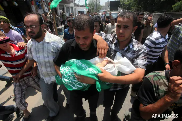 A Palestinian relative carries the body of two-year-old Hadeel al Hadad, during her funeral in Gaza City, Wednesday, June 20, 2012. Gaza health official Adham Abu Salmia said an explosion in a house killed al-Hadad and i...