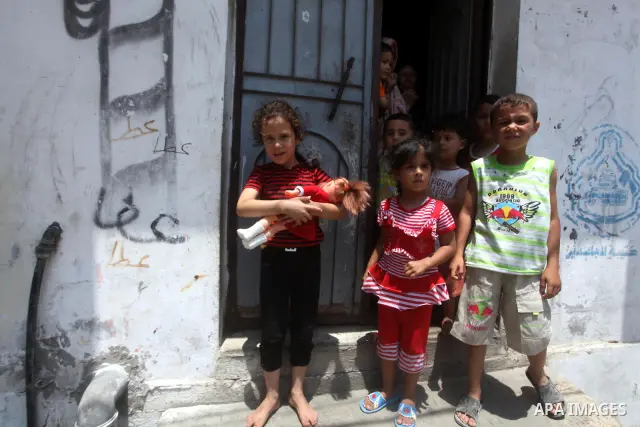 Palestinian children watch the funeral of Hadeel al-Hadad in Gaza City June 20, 2012. The two-year-old Gazan girl died and her brother was wounded when militants launched a rocket close by, Palestinian witnesses said. An...
