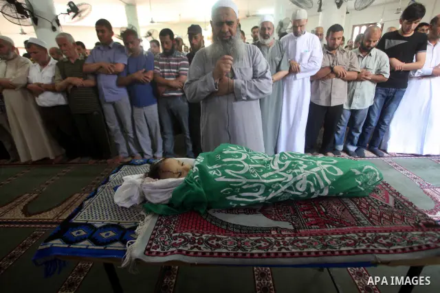 Palestinian mourners pray over the body of Hadeel al-Hadad during her funeral in Gaza City on 20 June 2012. Hadeel was killed June 19 when Palestinian militants launched a rocket from Gaza City, which failed to reach its...