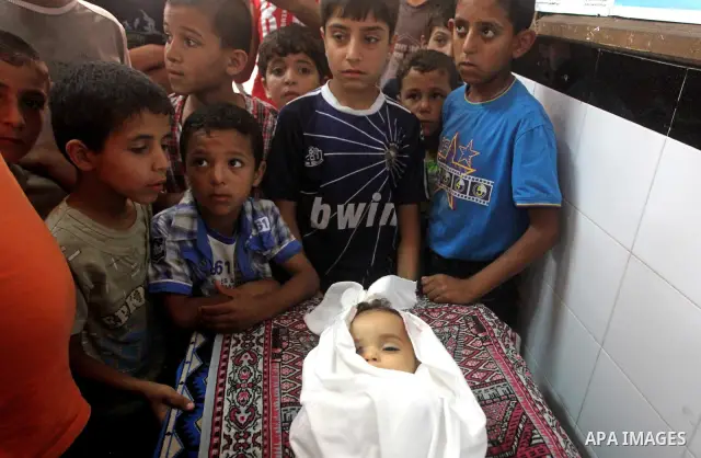 Palestinian children watch the funeral of Hadeel al-Hadad in Gaza City June 20, 2012. The two-year-old Gazan girl died and her brother was wounded when militants launched a rocket close by, Palestinian witnesses said. An...