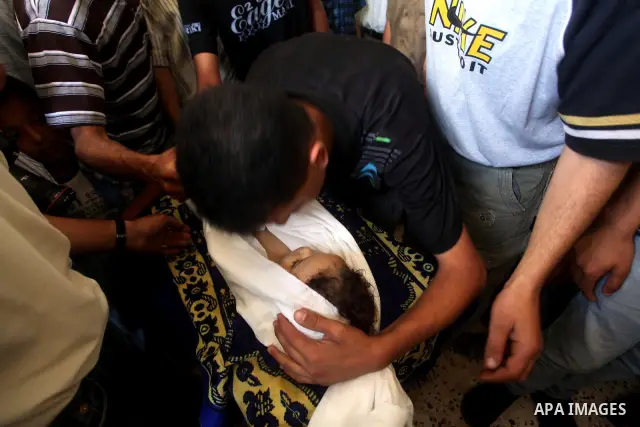 A Palestinian relative kisses the body of two-year-old Hadeel al Hadad, during her funeral in Gaza City, Wednesday, June 20, 2012. Gaza health official Adham Abu Salmia said an explosion in a house killed al-Hadad and in...