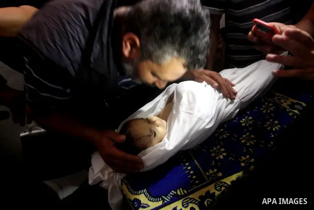 A Palestinian relative kisses the body of two-year-old Hadeel al Hadad, during her funeral in Gaza City, Wednesday, June 20, 2012. Gaza health official Adham Abu Salmia said an explosion in a house killed al-Hadad and in...