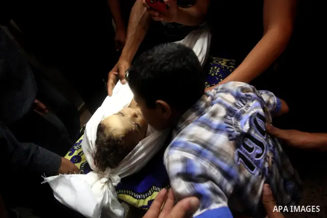 A Palestinian relative kisses the body of two-year-old Hadeel al Hadad, during her funeral in Gaza City, Wednesday, June 20, 2012. Gaza health official Adham Abu Salmia said an explosion in a house killed al-Hadad and in...