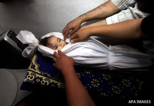 Palestinian mourners pray over the body of Hadeel al-Hadad during her funeral in Gaza City on 20 June 2012. Hadeel was killed June 19 when Palestinian militants launched a rocket from Gaza City, which failed to reach its...