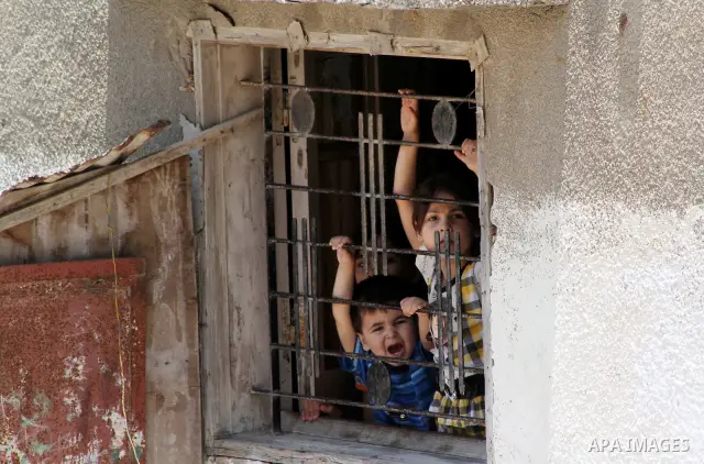 Palestinian children watch the funeral of Hadeel al-Hadad in Gaza City June 20, 2012. The two-year-old Gazan girl died and her brother was wounded when militants launched a rocket close by, Palestinian witnesses said. An...