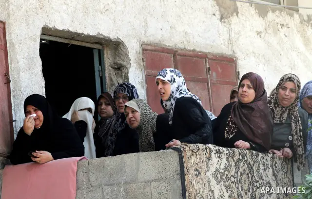 Palestinian women watch the funeral of two-year-old Hadeel al Hadad, during her funeral in Gaza City, Wednesday, June 20, 2012. Gaza health official Adham Abu Salmia said an explosion in a house killed al-Hadad and injur...