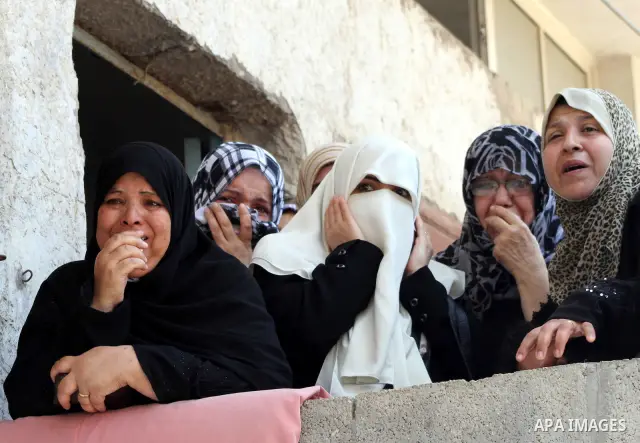 Palestinian women watch the funeral of two-year-old Hadeel al Hadad, during her funeral in Gaza City, Wednesday, June 20, 2012. Gaza health official Adham Abu Salmia said an explosion in a house killed al-Hadad and injur...