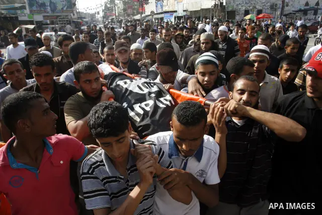 Relatives carry the body of Palestinian militant Galib Rmelat during his funeral in Rafah in the southern Gaza Strip June 20, 2012. Israeli air strikes killed a Palestinian militant and a 14-year-old boy as fighting acro...