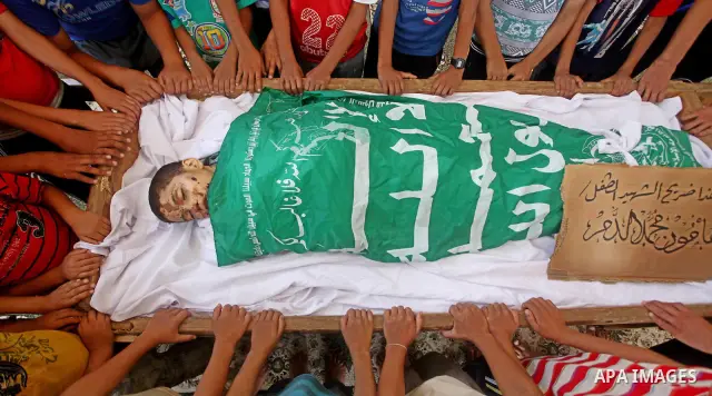 friends of 14-year old Palestinian Moamen al-Adam, who was killed in an Israeli air strike the day before, bids farewell to him during his funeral procession in Gaza city on June 21, 2012. The latest attacks follow three...