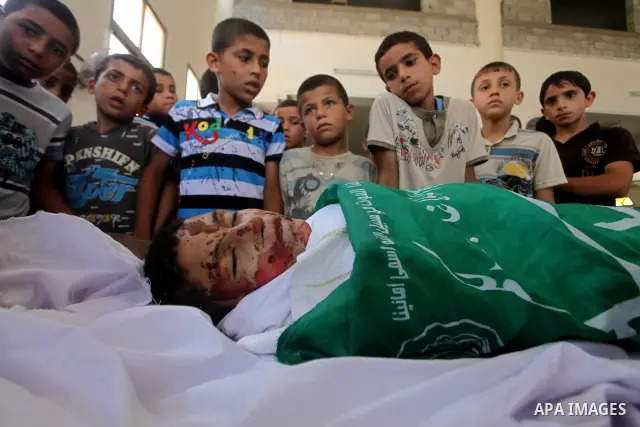 friends of 14-year old Palestinian Moamen al-Adam, who was killed in an Israeli air strike the day before, bids farewell to him during his funeral procession in Gaza city on June 21, 2012. The latest attacks follow three...