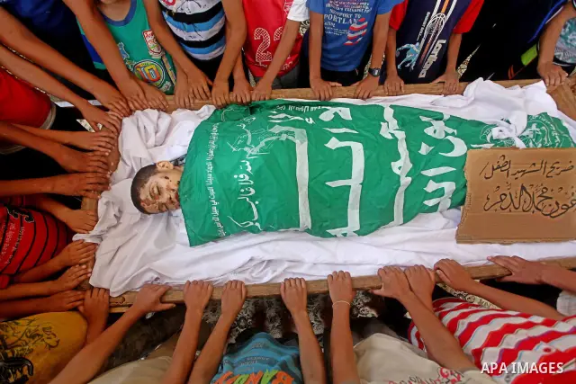 friends of 14-year old Palestinian Moamen al-Adam, who was killed in an Israeli air strike the day before, bids farewell to him during his funeral procession in Gaza city on June 21, 2012. The latest attacks follow three...