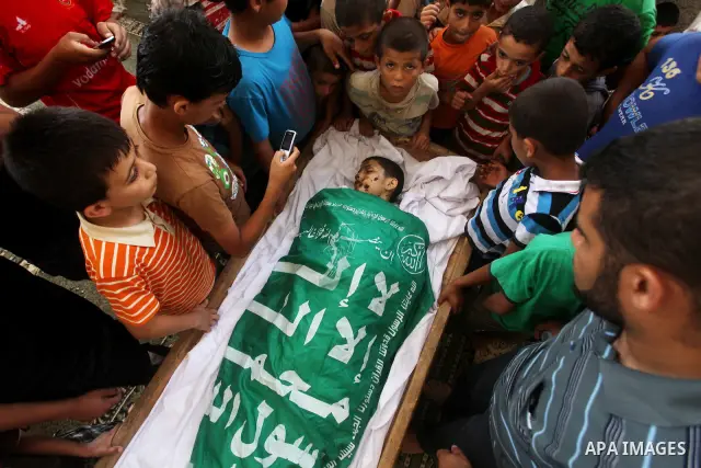 friends of 14-year old Palestinian Moamen al-Adam, who was killed in an Israeli air strike the day before, bids farewell to him during his funeral procession in Gaza city on June 21, 2012. The latest attacks follow three...