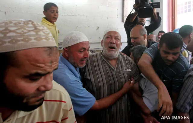 Palestinian Mohammed al-Dam grieves during the funeral of his son Mamon al-Dam, 14, in Gaza City, Thursday, June 21, 2012. Al Dam was killed on Wednesday during an Israeli air strike while he was playing at his family fa...
