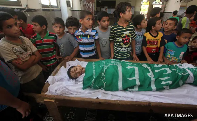 friends of 14-year old Palestinian Moamen al-Adam, who was killed in an Israeli air strike the day before, bids farewell to him during his funeral procession in Gaza city on June 21, 2012. The latest attacks follow three...