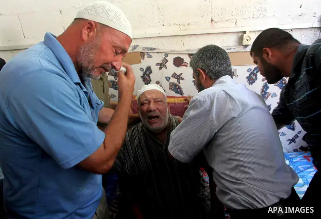Palestinian Mohammed al-Dam grieves during the funeral of his son Mamon al-Dam, 14, in Gaza City, Thursday, June 21, 2012. Al Dam was killed on Wednesday during an Israeli air strike while he was playing at his family fa...