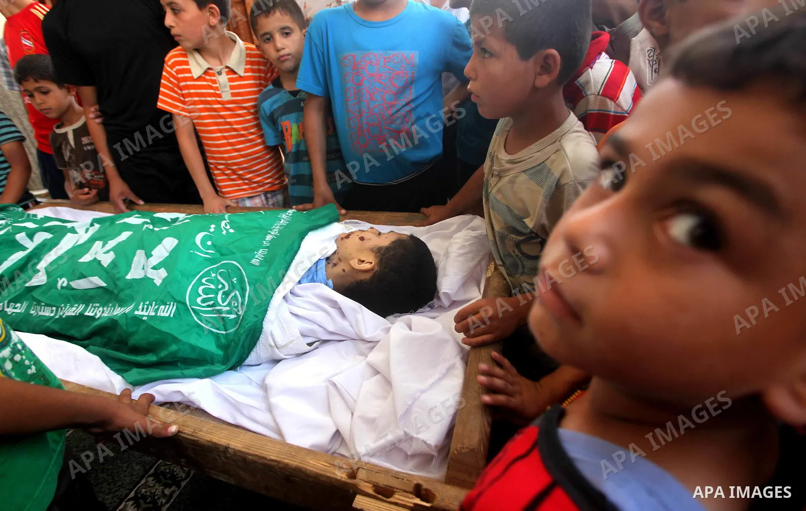 Friends of 14-year old Palestinian Moamen al-Adam, who was killed in an Israeli air strike the day before, bids farewell to him during his funeral procession in Gaza city on June 21, 2012. The latest attacks follow three...
