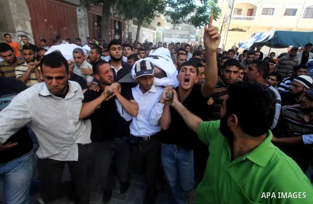 Palestinian mourners carry the body of a militant of al-Qassam brigades Thair Al-Baik, 30, during his funeral in Jabalia refugee camp in the northern Gaza Strip on June 21, 2012. Al-Baik one of two fighters from al-Qassa...