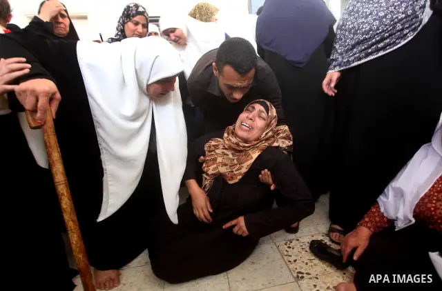 A Palestinian relative of a militant of al-Qassam brigades Thair Al-Baik, 30, collapses as she mourns during his funeral in Jabalia refugee camp in the northern Gaza Strip on June 21, 2012. Al-Baik one of two fighters fr...