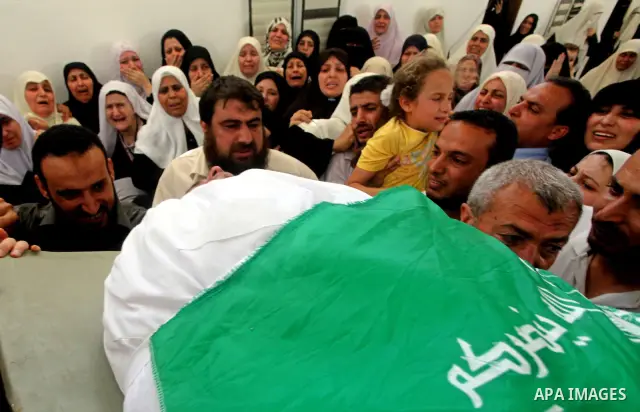 A daughter of a Palestinian militant of al-Qassam brigades Thair Al-Baik mourns during his funeral in Jabalya camp in the northern Gaza Strip June 21, 2012. Al-Baik one of two fighters from al-Qassam brigades the armed w...