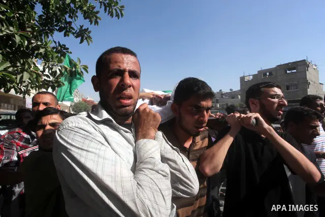 Palestinian mourners carry the body of a militant of al-Qassam brigades Thair Al-Baik, 30, during his funeral in Jabalia refugee camp in the northern Gaza Strip on June 21, 2012. Al-Baik one of two fighters from al-Qassa...