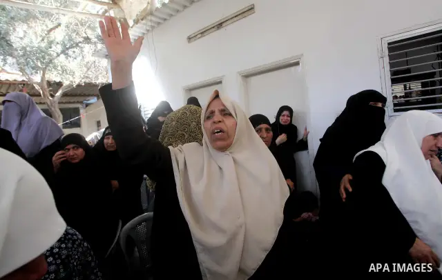 Palestinian relatives of a militant of al-Qassam brigades Thair Al-Baik, 30, mourn during his funeral in Jabalia refugee camp in the northern Gaza Strip on June 21, 2012. Al-Baik one of two fighters from al-Qassam brigad...