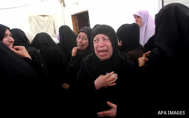 Palestinian relatives of a militant of al-Qassam brigades Thair Al-Baik, 30, mourn during his funeral in Jabalia refugee camp in the northern Gaza Strip on June 21, 2012. Al-Baik one of two fighters from al-Qassam brigad...