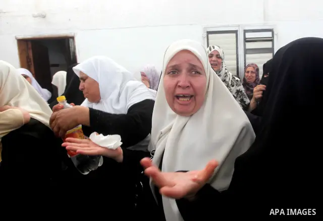 Palestinian relatives of a militant of al-Qassam brigades Thair Al-Baik, 30, mourn during his funeral in Jabalia refugee camp in the northern Gaza Strip on June 21, 2012. Al-Baik one of two fighters from al-Qassam brigad...