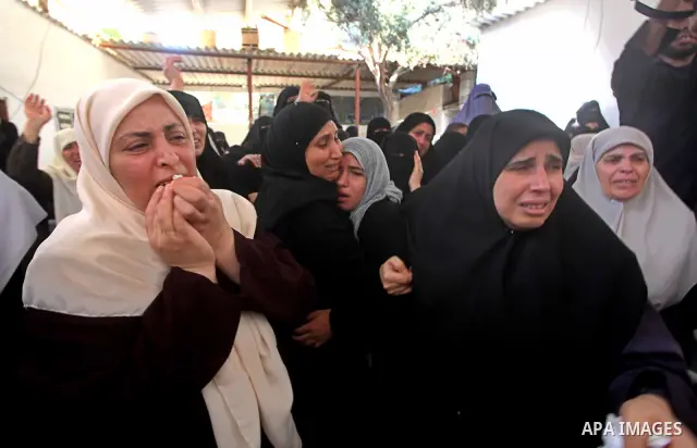 Palestinian relatives of a militant of al-Qassam brigades Thair Al-Baik, 30, mourn during his funeral in Jabalia refugee camp in the northern Gaza Strip on June 21, 2012. Al-Baik one of two fighters from al-Qassam brigad...