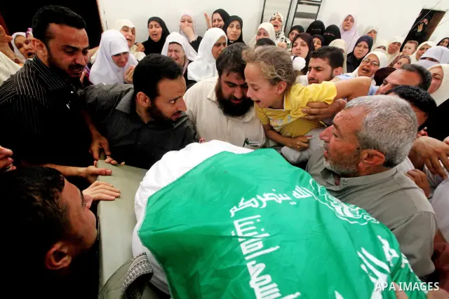 A daughter of a Palestinian militant of al-Qassam brigades Thair Al-Baik mourns during his funeral in Jabalya camp in the northern Gaza Strip June 21, 2012. Al-Baik one of two fighters from al-Qassam brigades the armed w...