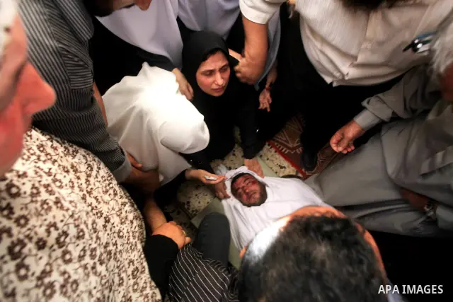 Palestinian relatives of a militant of al-Qassam brigades Thair Al-Baik, 30, mourn during his funeral in Jabalia refugee camp in the northern Gaza Strip on June 21, 2012. Al-Baik one of two fighters from al-Qassam brigad...