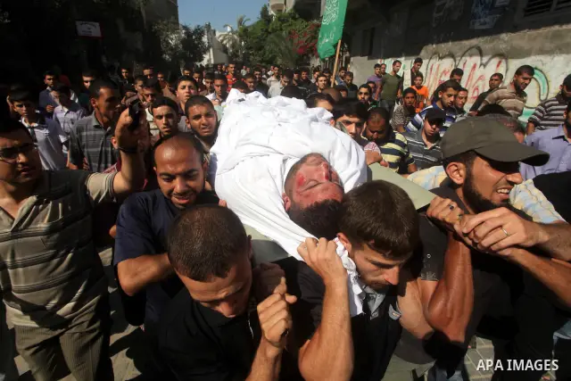 Palestinian mourners carry the body of a militant of al-Qassam brigades Thair Al-Baik, 30, during his funeral in Jabalia refugee camp in the northern Gaza Strip on June 21, 2012. Al-Baik one of two fighters from al-Qassa...