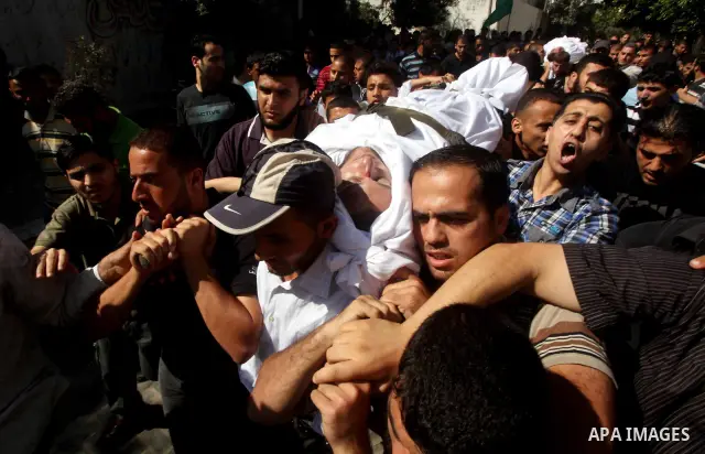 Palestinian mourners carry the body of a militant of al-Qassam brigades Thair Al-Baik, 30, during his funeral in Jabalia refugee camp in the northern Gaza Strip on June 21, 2012. Al-Baik one of two fighters from al-Qassa...