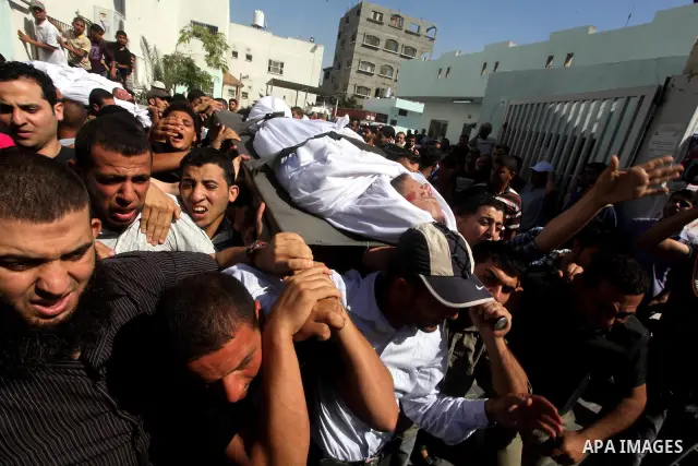 Palestinian mourners carry the body of a militant of al-Qassam brigades Thair Al-Baik, 30, during his funeral in Jabalia refugee camp in the northern Gaza Strip on June 21, 2012. Al-Baik one of two fighters from al-Qassa...