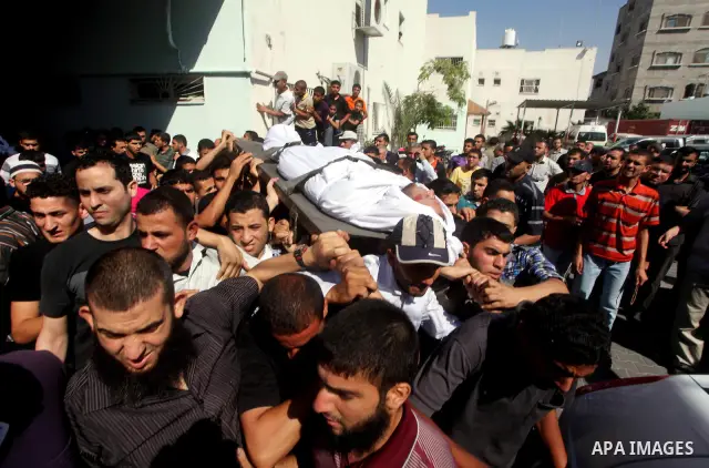 Palestinian mourners carry the body of a militant of al-Qassam brigades Thair Al-Baik, 30, during his funeral in Jabalia refugee camp in the northern Gaza Strip on June 21, 2012. Al-Baik one of two fighters from al-Qassa...