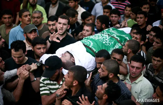 Palestinian mourners carry the body of Hamas militant Thair al-Bik, and Mohammed al-Khaldi , during their funeral in Jabaliya Refugee Camp, northern Gaza Strip, Thursday, June 21, 2012. Al-Bik and Al-Khaldi two Hamas mil...