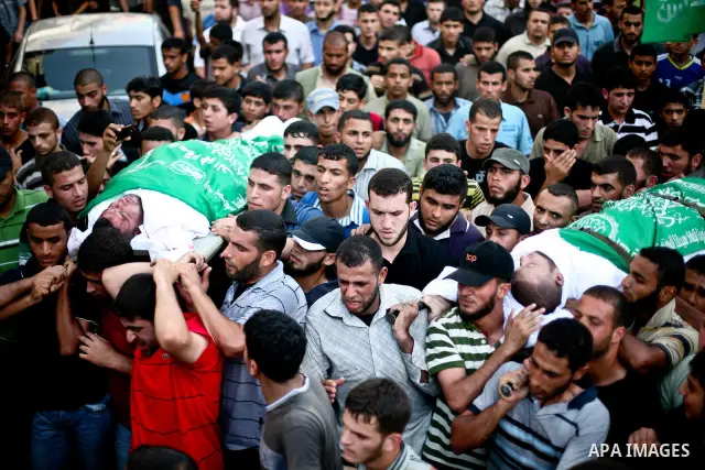 Palestinian mourners carry the body of Hamas militant Thair al-Bik, and Mohammed al-Khaldi , during their funeral in Jabaliya Refugee Camp, northern Gaza Strip, Thursday, June 21, 2012. Al-Bik and Al-Khaldi two Hamas mil...