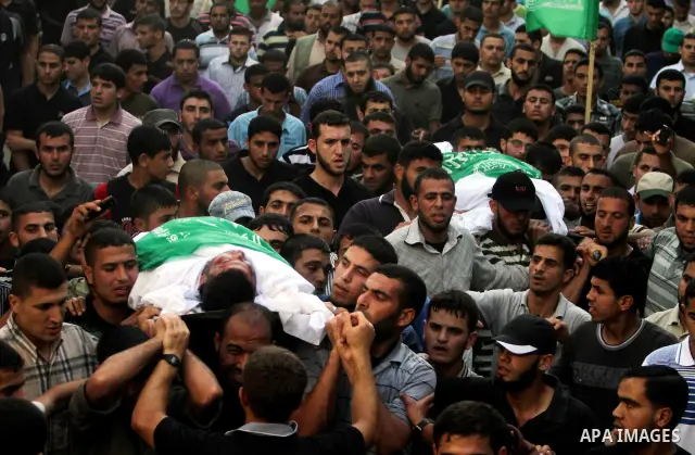 Palestinian mourners carry the body of Hamas militant Thair al-Bik, and Mohammed al-Khaldi , during their funeral in Jabaliya Refugee Camp, northern Gaza Strip, Thursday, June 21, 2012. Al-Bik and Al-Khaldi two Hamas mil...