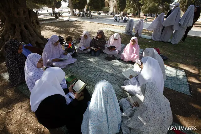 Palestinian girls read the Holy Quran during the summer camps at Al-Aqsa mosque in the old city of Jerusalem on 21 June 2012. Photo by Mahfouz Abu Turk.