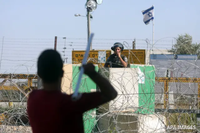 Palestinian protestors shout anti-Israel slogans at soldiers manning the Bitwonia crossing during a demonstration outside Ofer prison, near the West Bank city of Ramallah, in solidarity with Palestinian prisoners being h...